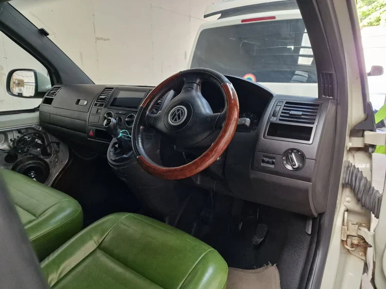 Lucille 2013 Volkswagen Transporter T5 interior with green leather seats and wooden steering wheel